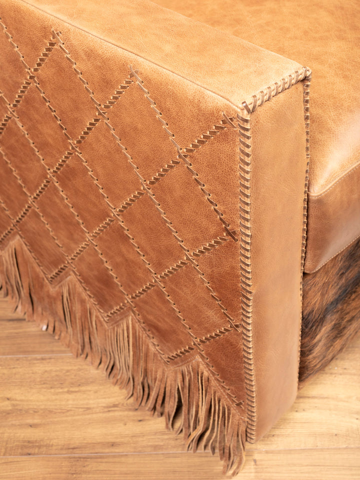 Side view showing diamond-stitched panels and fringe skirt on Western leather swivel chair