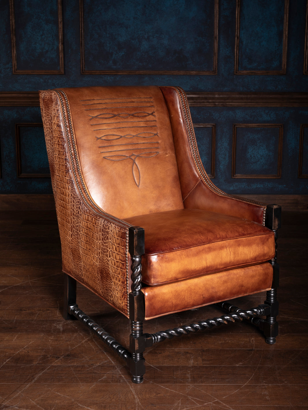 Burnished leather accent chair with Western boot stitch detailing and twisted wood legs, showcasing premium saddle leather and intricate craftsmanship.