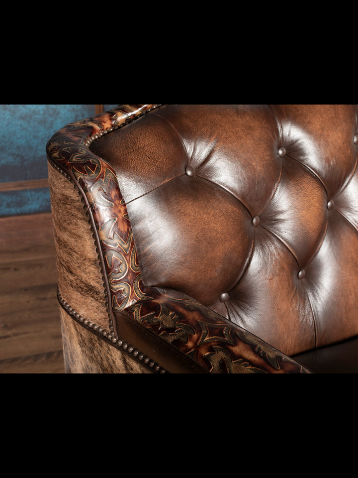Close-up of tooled leather trim and deep tufted brown leather backrest