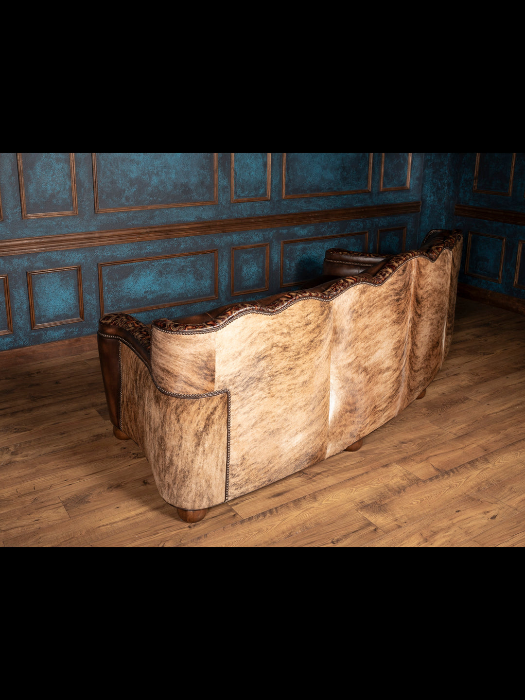 Back view of sofa: Back of Utah sofa upholstered in light brindle hair-on-hide with curved silhouette