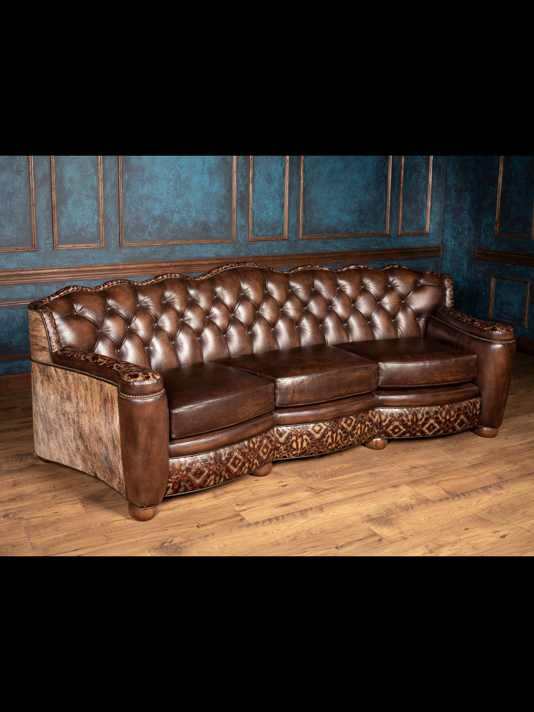 Angled front view: Three-seater brown leather sofa with Western embossed trim and rounded arms