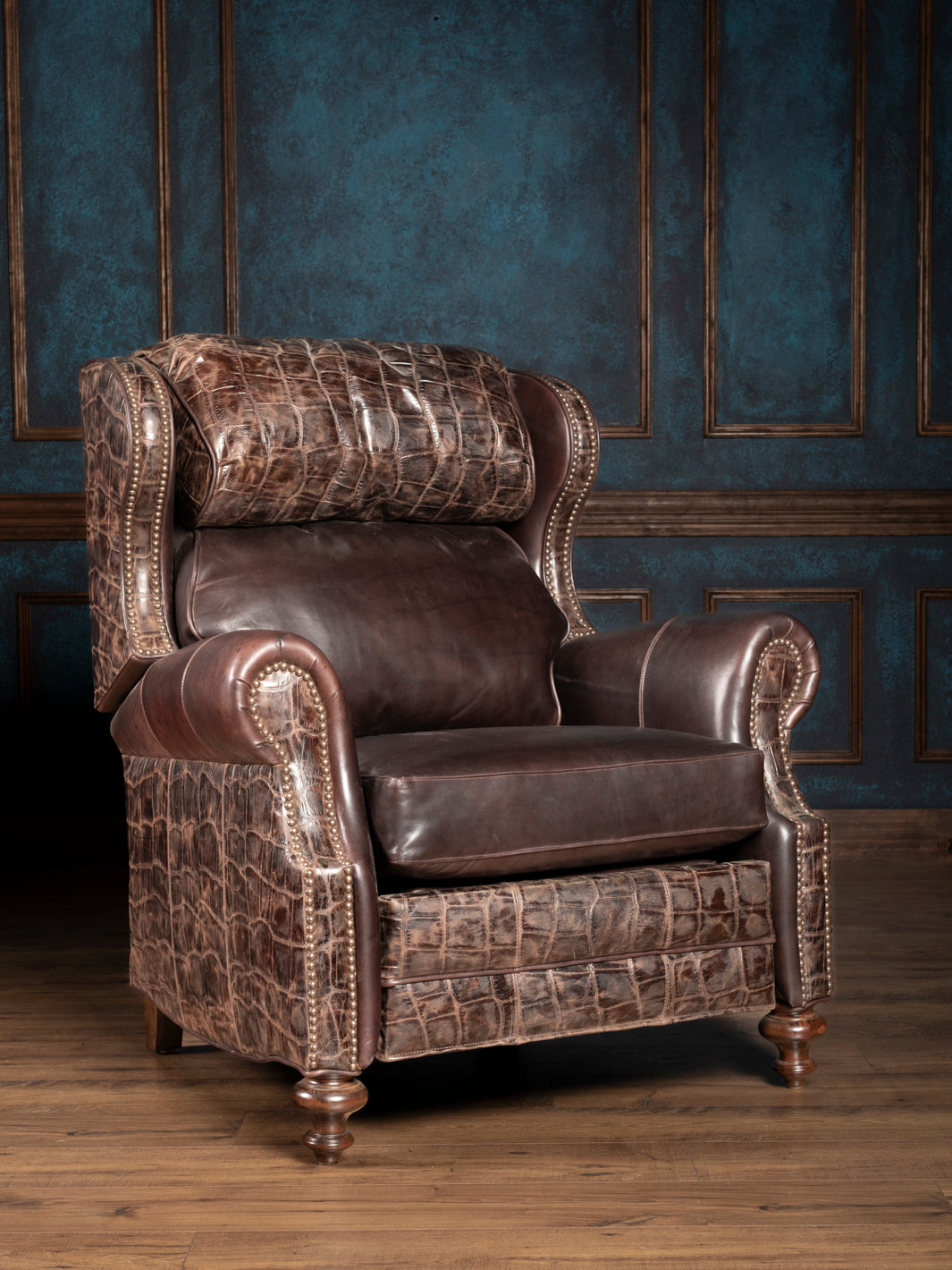 A chocolate brown leather recliner chair with embossed gator patterns, plush cushioning, and a wood panel background.