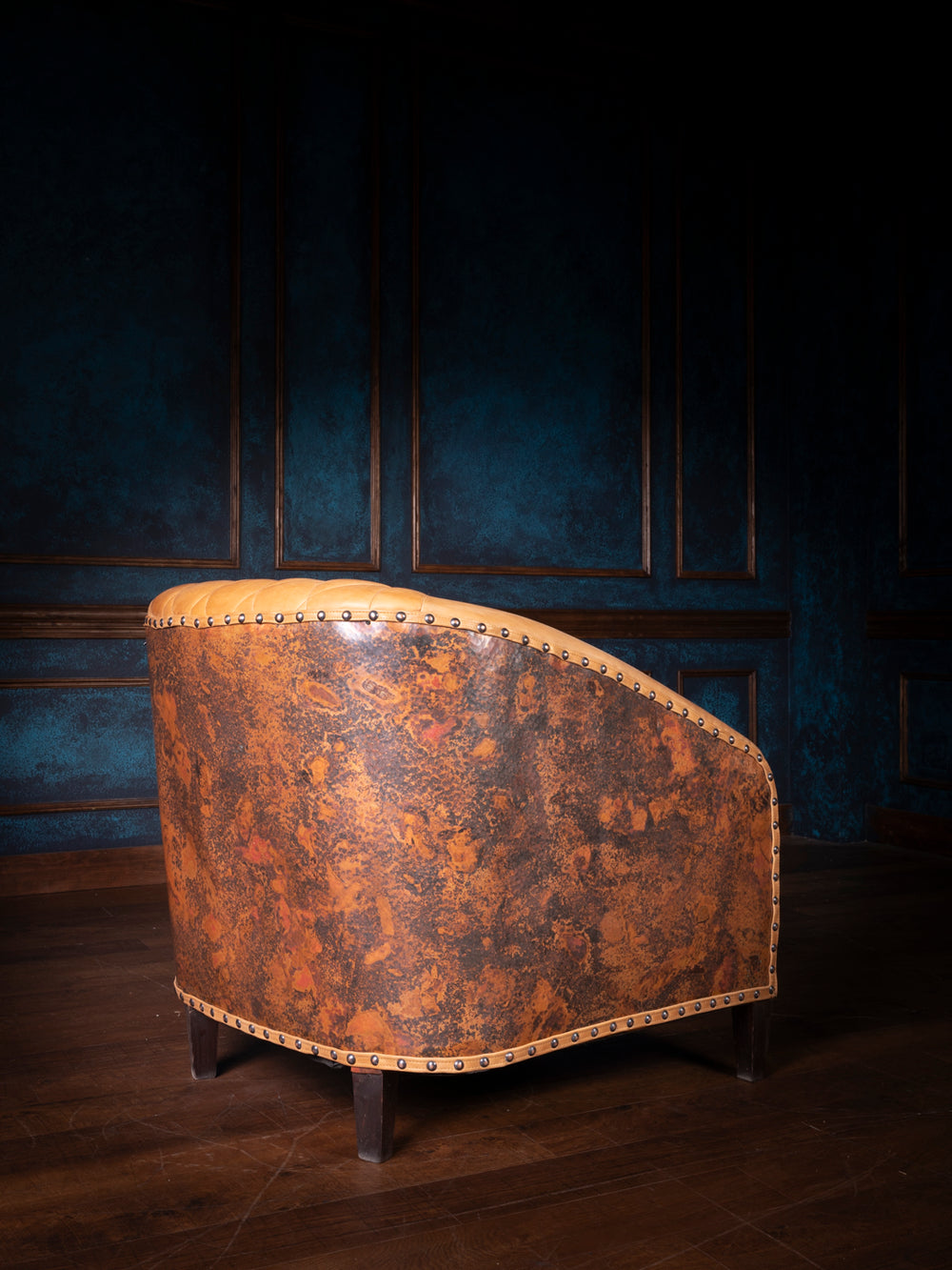 Back view of the copper accent chair showcasing its distressed metallic leather panel and curved silhouette.