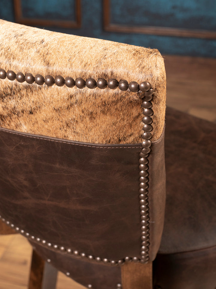 Side profile of handcrafted cowhide and leather bar stool with swivel wood base
