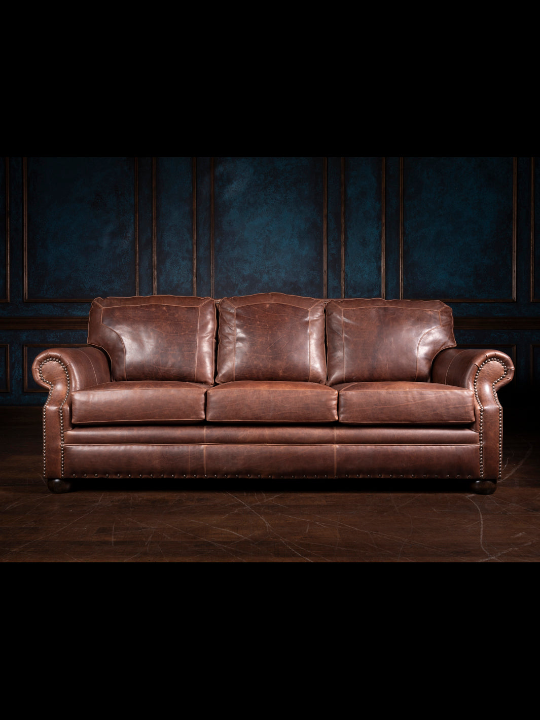 Full front view of a Western-style leather sofa with deep brown Red Oak leather, featuring three seat cushions and traditional rolled arms with nailhead trim.