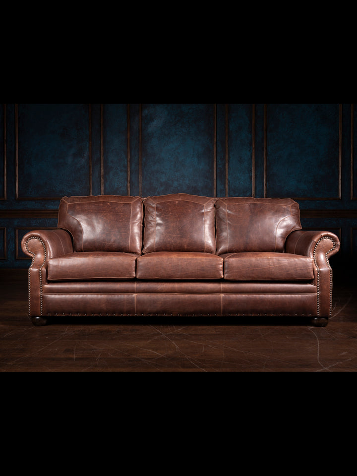 Full front view of a Western-style leather sofa with deep brown Red Oak leather, featuring three seat cushions and traditional rolled arms with nailhead trim.