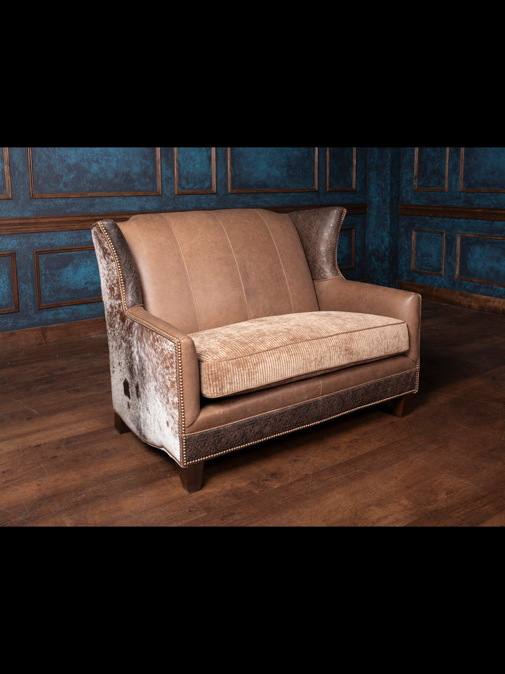Full view of the Hazelnut Leather Settee in a cozy living room setting, with a focus on the premium hair-on-hide accents and rich Rustler leather upholstery.