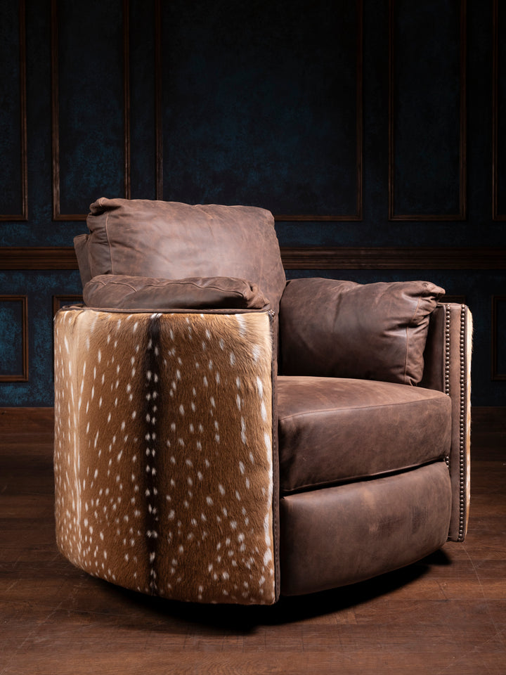 A brown leather axis snug swivel recliner chair with a patterned accent on the side, set against a dimly lit room.