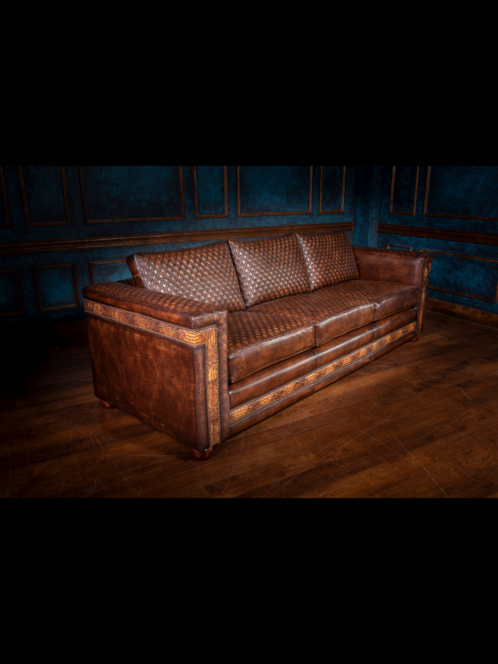 Angled view of the western quilted leather architect sofa showcasing hand-tooled leather detailing, deep seat cushions, and sleek boxy arms.