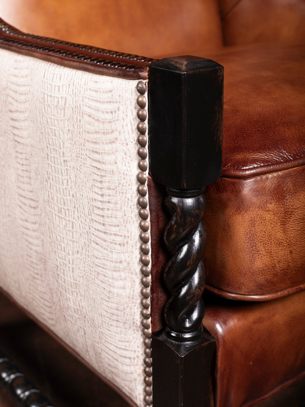 Detailed view of the hand-burnished leather seat and twisted wood leg of the Savannah Leather & Croc Accent Chair with premium craftsmanship and nailhead trim for a rustic, high-end look.