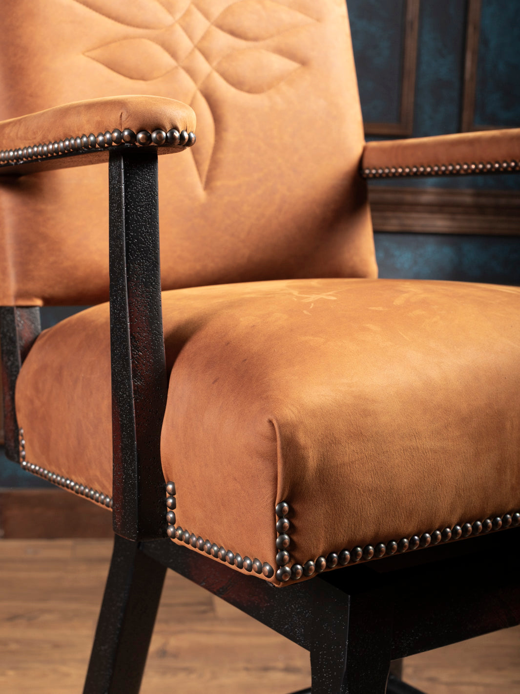 Detailed view of armrest and leather seat with antique nailhead trim on Sedona Saddle Leather Bar Stool
