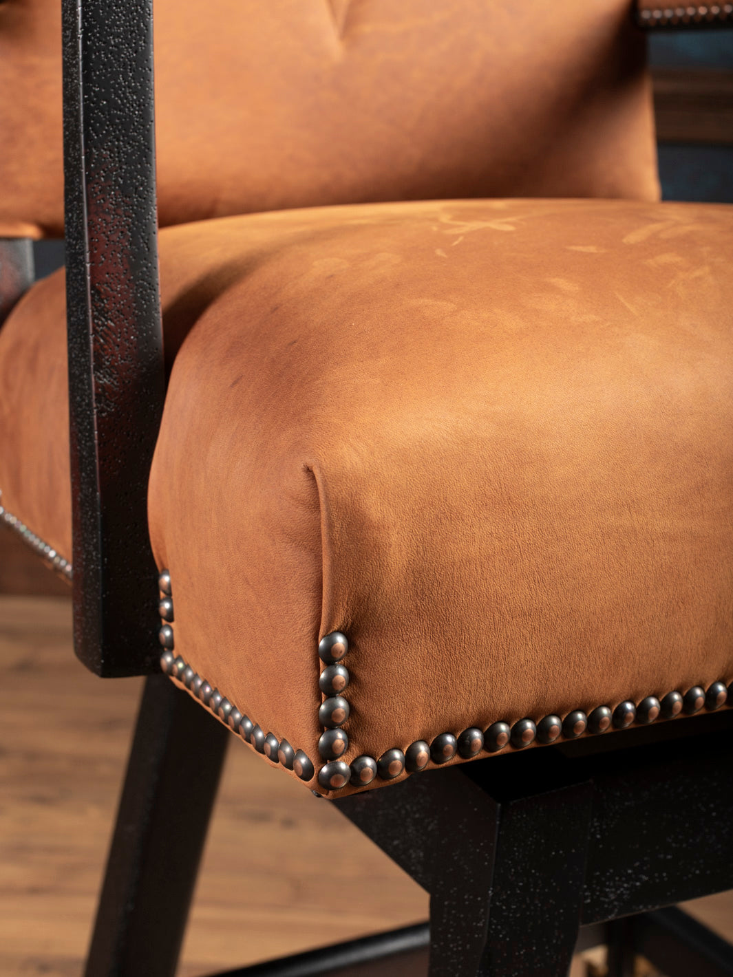 Angled close-up of bottom corner of seat and nailhead trim on Sedona Saddle Leather Bar Stool