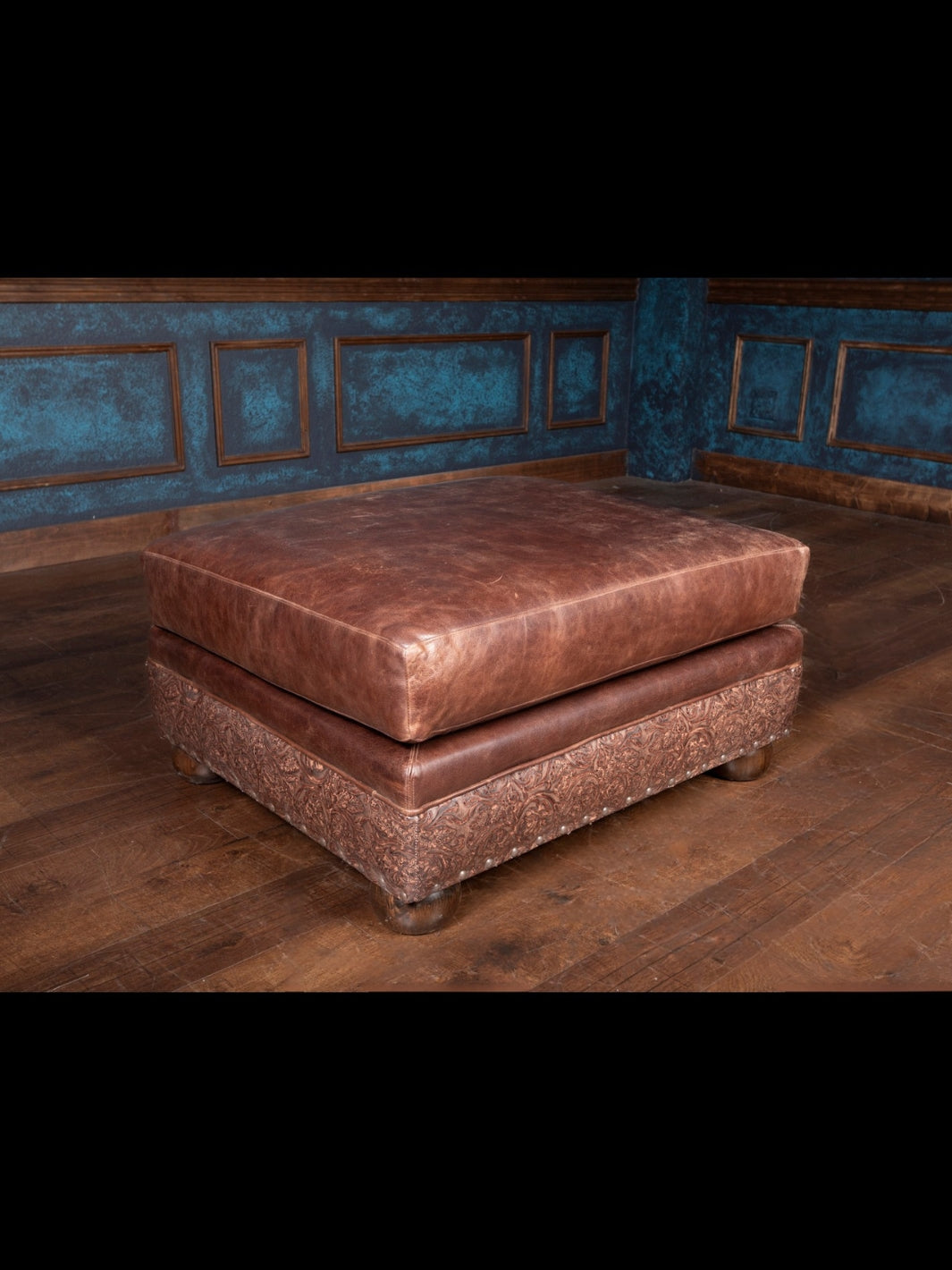 Matching brown leather ottoman with tooled leather base and plush cushion top, designed to pair with the Texas Luxe chair and a half for ultimate Western comfort.