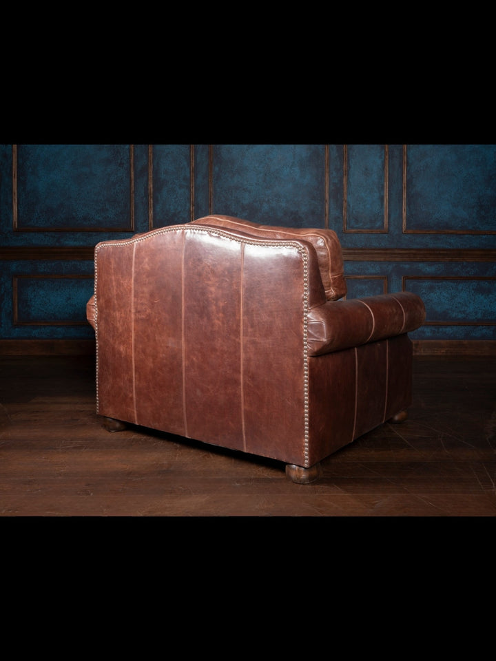 Back view of the Texas Luxe leather armchair with stitched leather panels and nailhead trim, offering a clean, refined finish from every angle.