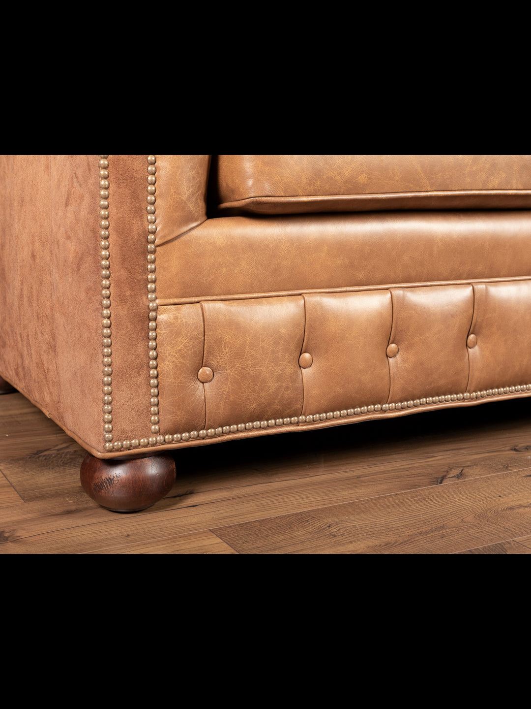Side view of sofa's curved bun feet and trim