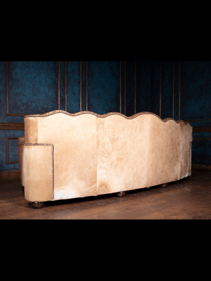 Rear angle of the Western Sunflower Utah Sofa showcasing its cream hair-on-hide leather and curved silhouette.