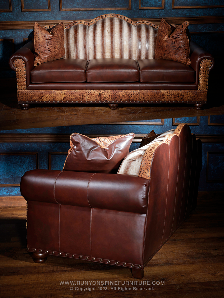 Full front and angled side view of a handcrafted western leather sofa showcasing a unique arched backrest, textured leather detailing, and contrasting exotic leather accents for a rustic luxury look.