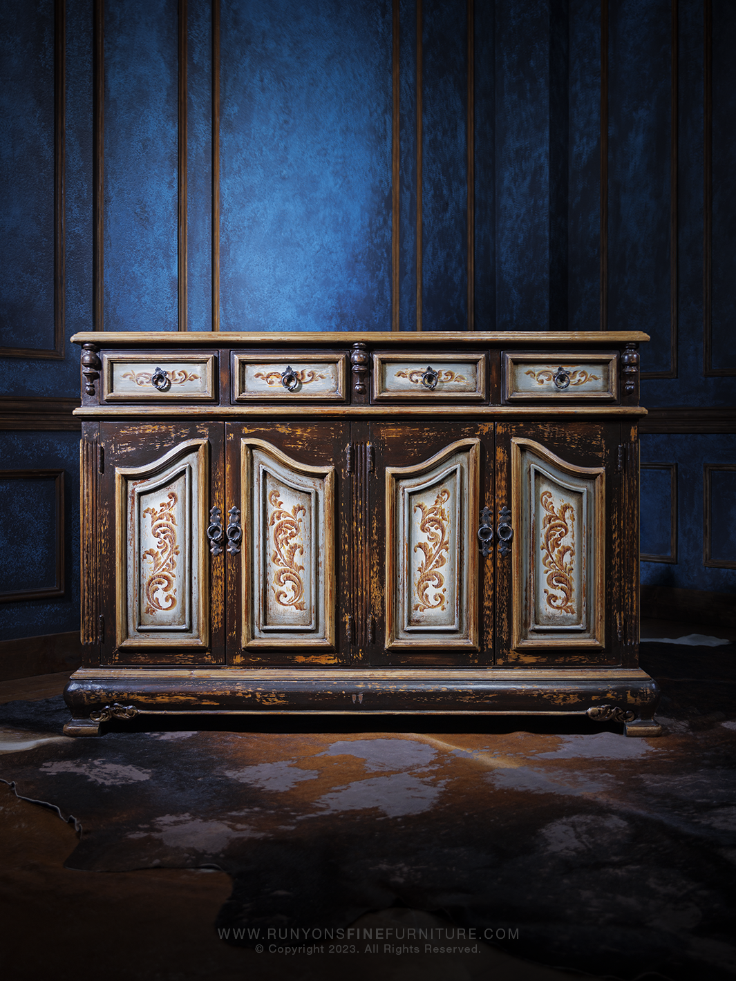 An Old World-style buffet with a distressed finish, featuring ornate carved details on the doors and drawers, accented with antique-style hardware.
