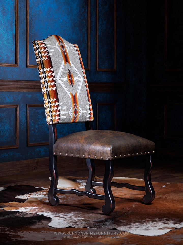 A Southwestern style dining chair with a geometric pattern on the backrest, genuine leather seat, and antique black frame.