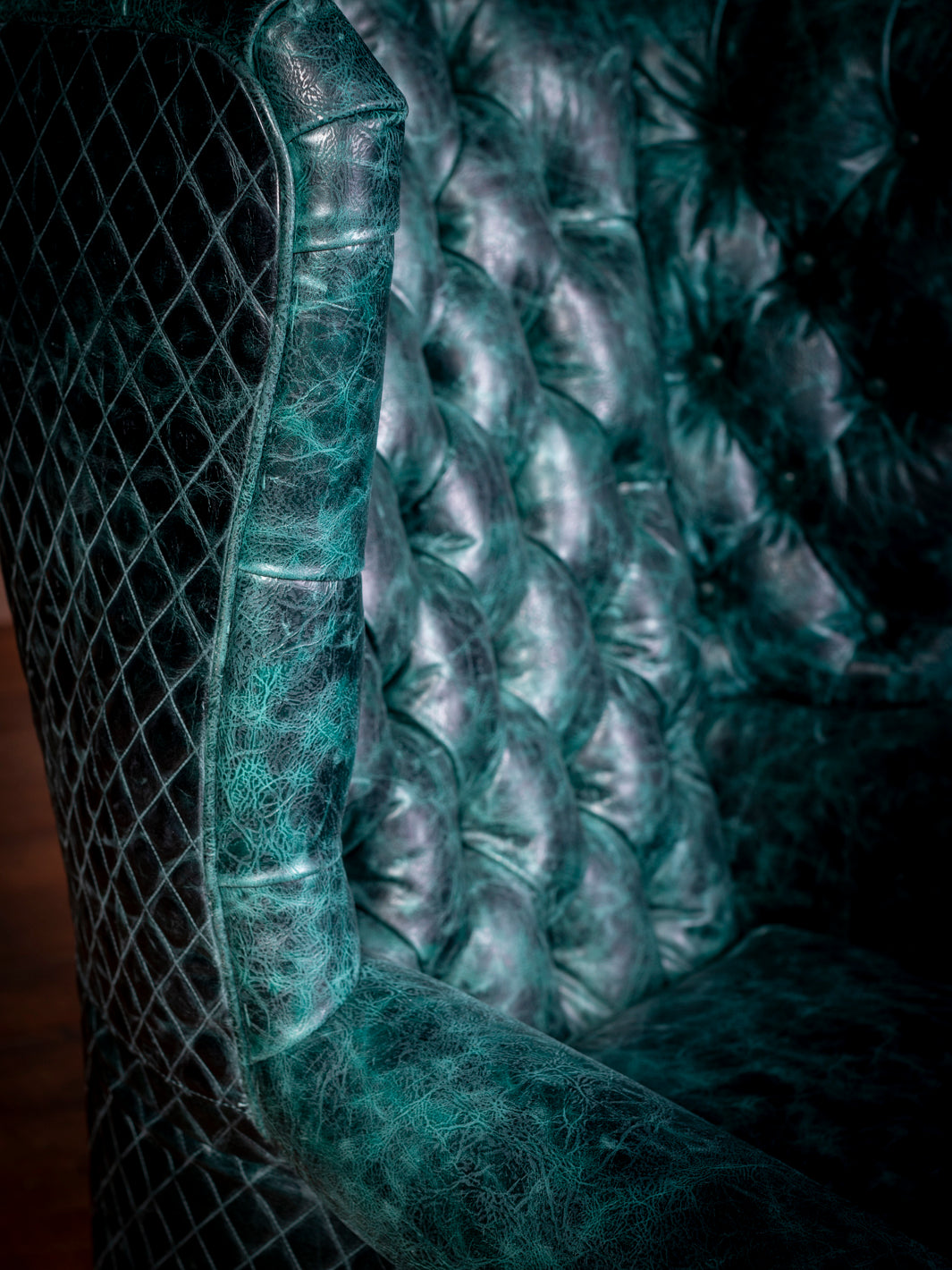 Detailed view of the fiber plush back cushions on the Tufted Teal Leather Wingback Chair, offering both luxury and support.