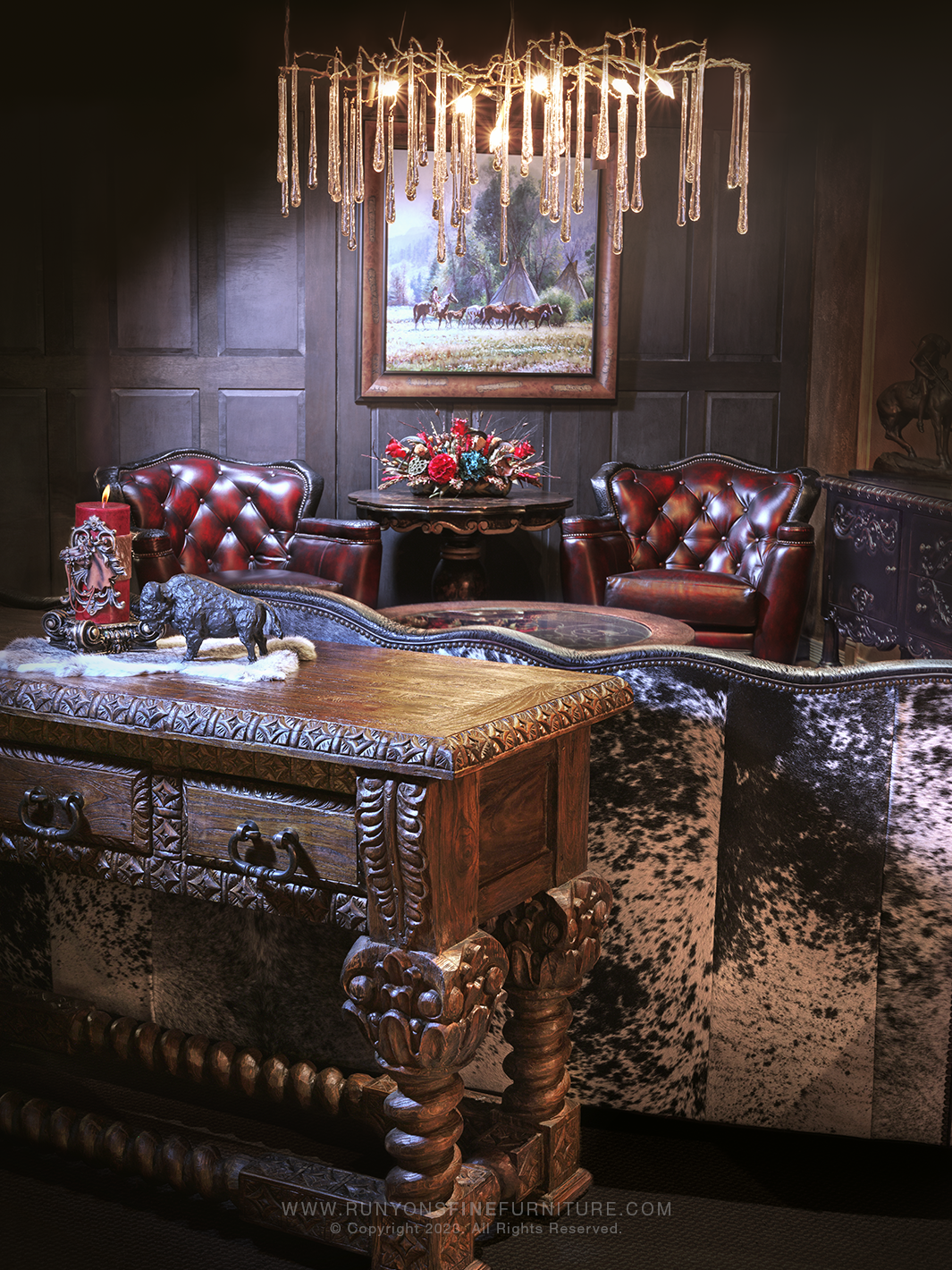 Elegant western interior showcasing a red tufted leather sofa with cowhide back, flanked by matching armchairs and rustic wood furniture. Room styled with rich textures, a chandelier, and western art.