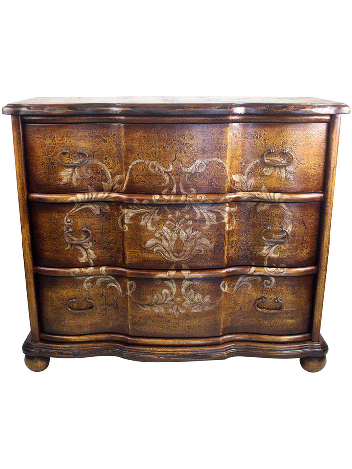 A wooden dresser with hand painted floral designs in gold and beige colors on a dark background.