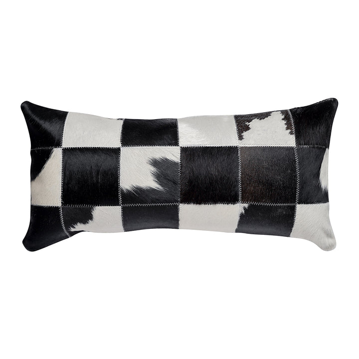 Rectangular lumbar pillow with a black and white hair on hide patchwork design, featuring a grid of contrasting black and white squares.
