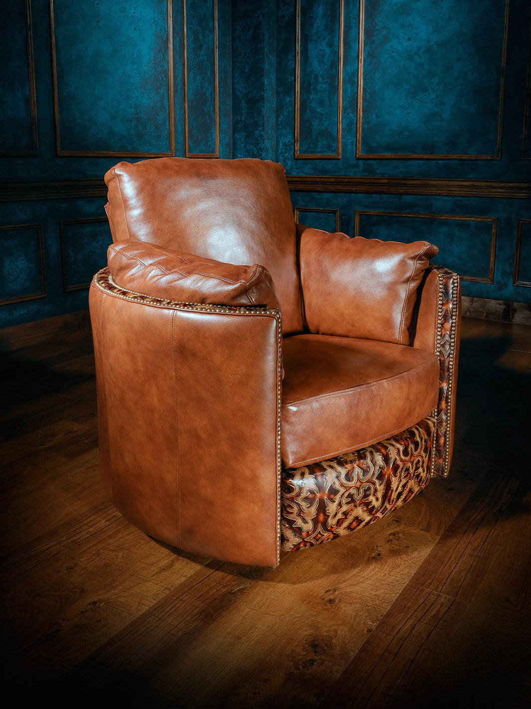 A brown leather snug swivel recliner chair placed on a wooden floor against a blue panelled wall, with no visible occupants.