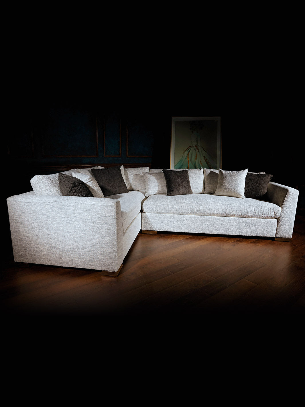 A beige Outlanders Sectional Sofa with plush cushions, set in a dimly lit room.