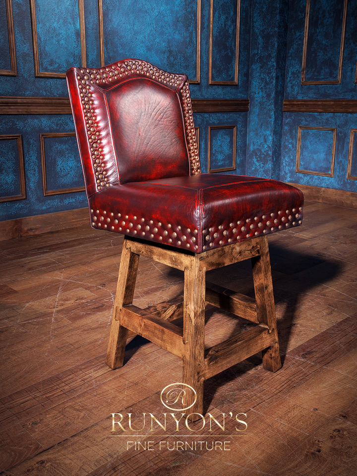 A red upholstered armless bar stool with a western rustic style, featuring a wooden base and leather upholstery.
