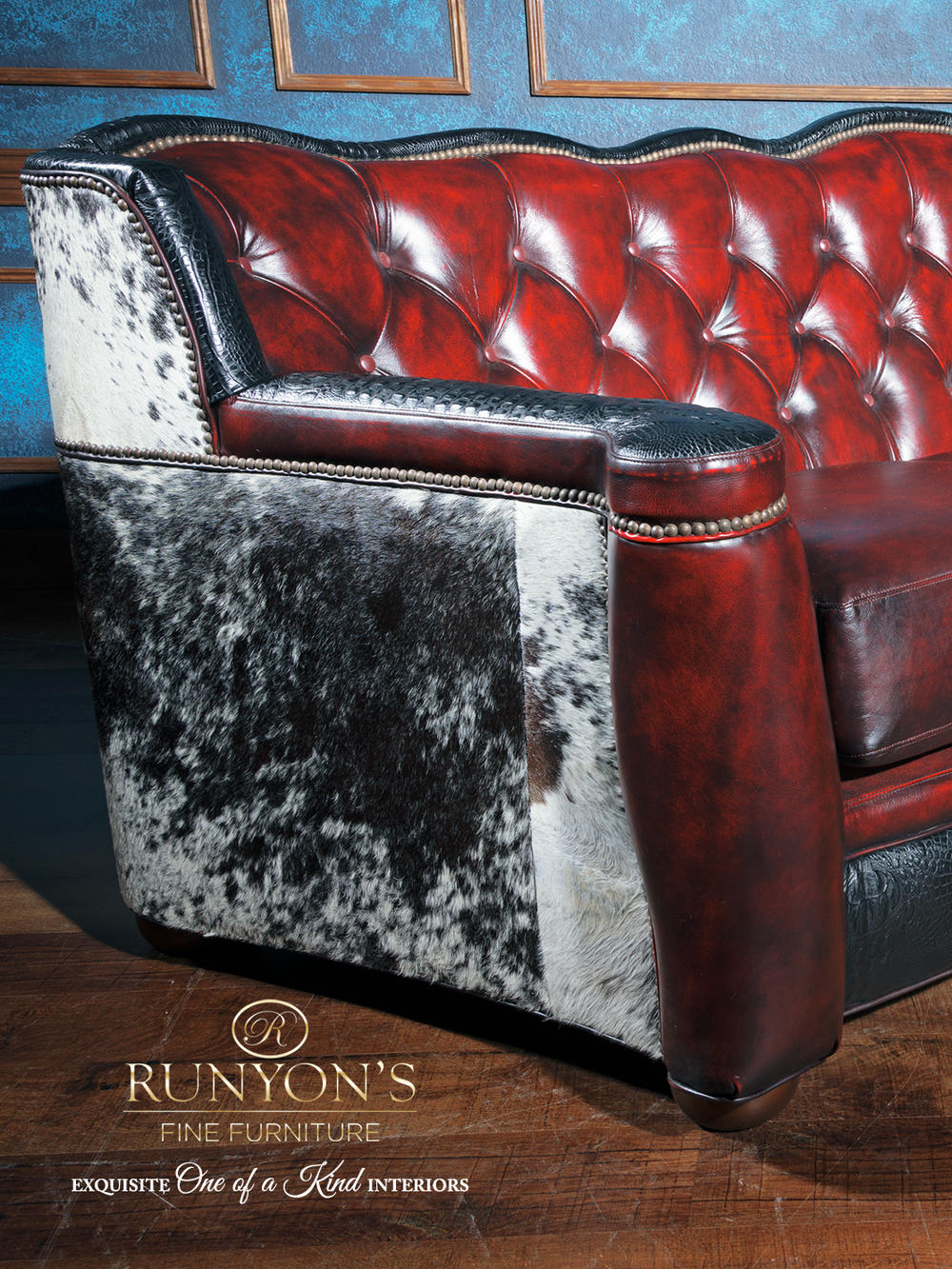 Close-up view of a western leather sofa with deep red tufted leather, black croc-embossed trim, and speckled cowhide side panel. Features nailhead trim and rich texture for a bold rustic look.