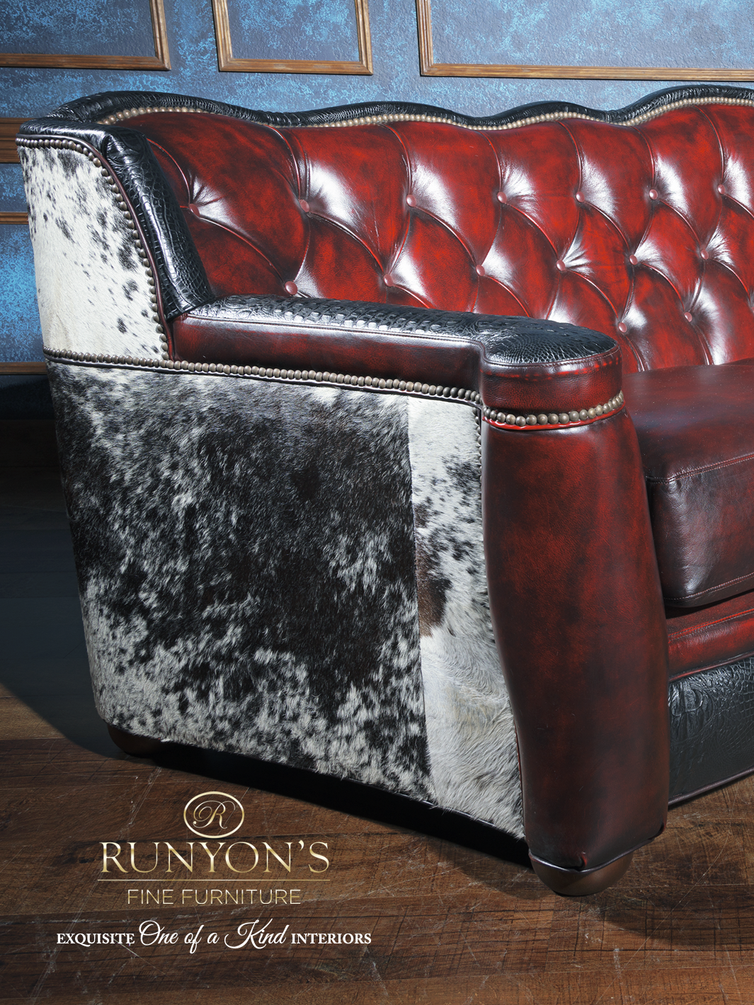 Close-up view of a western leather sofa with deep red tufted leather, black croc-embossed trim, and speckled cowhide side panel. Features nailhead trim and rich texture for a bold rustic look.