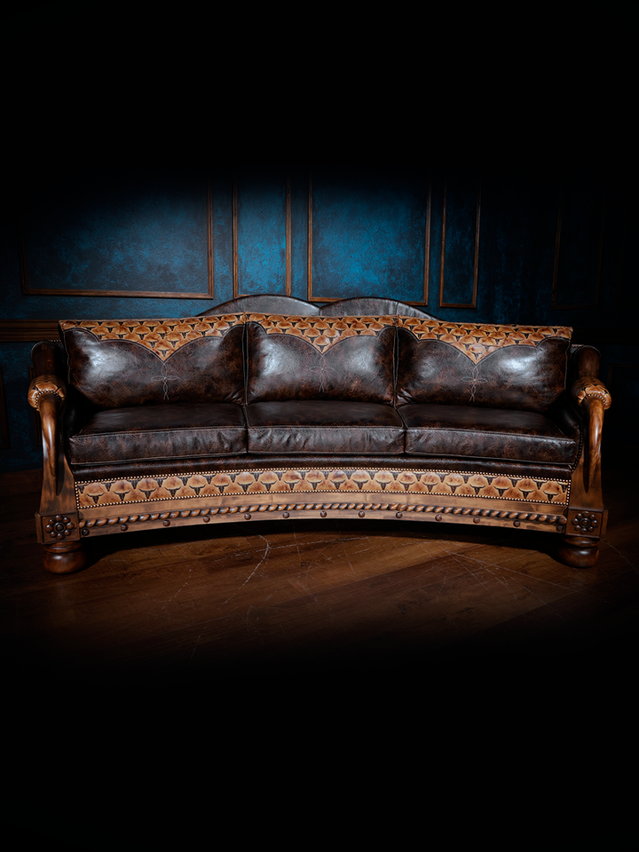 Full front view of a dark brown leather western sofa with detailed tooling and decorative woodwork along the arms and base