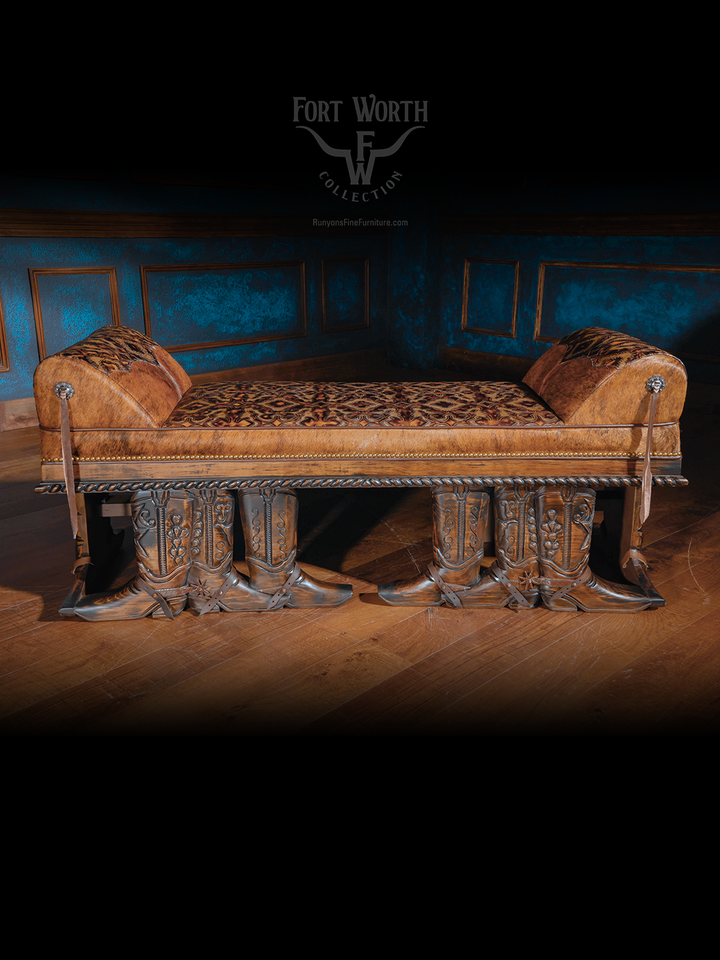 Western-style bench with leather and patterned fabric, supported by cowboy boot-shaped carved wooden legs.