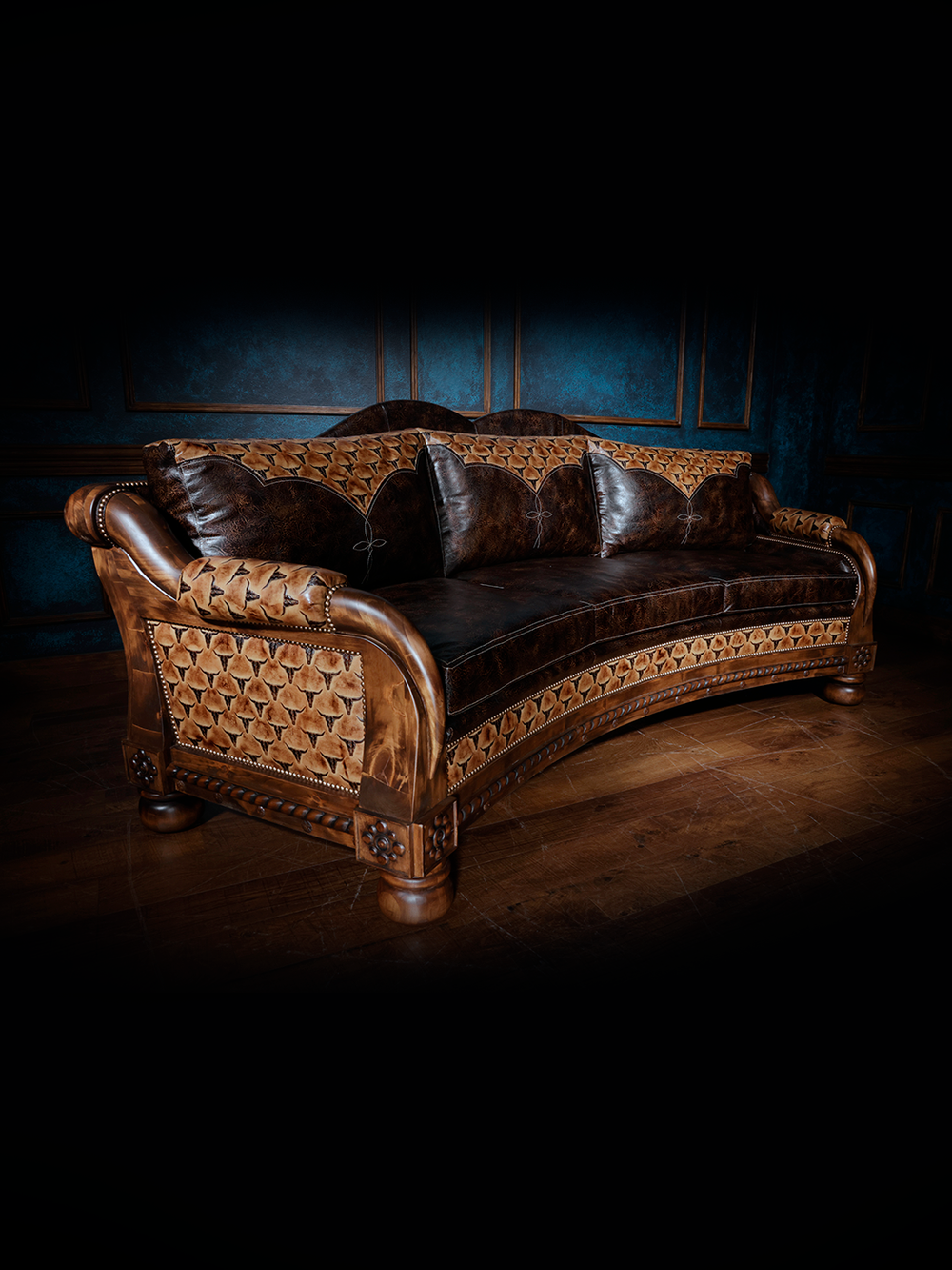 Angled view of a western leather sofa with tooled leather panels and sculpted wood accents, featuring a mix of rich brown tones and rustic textures.