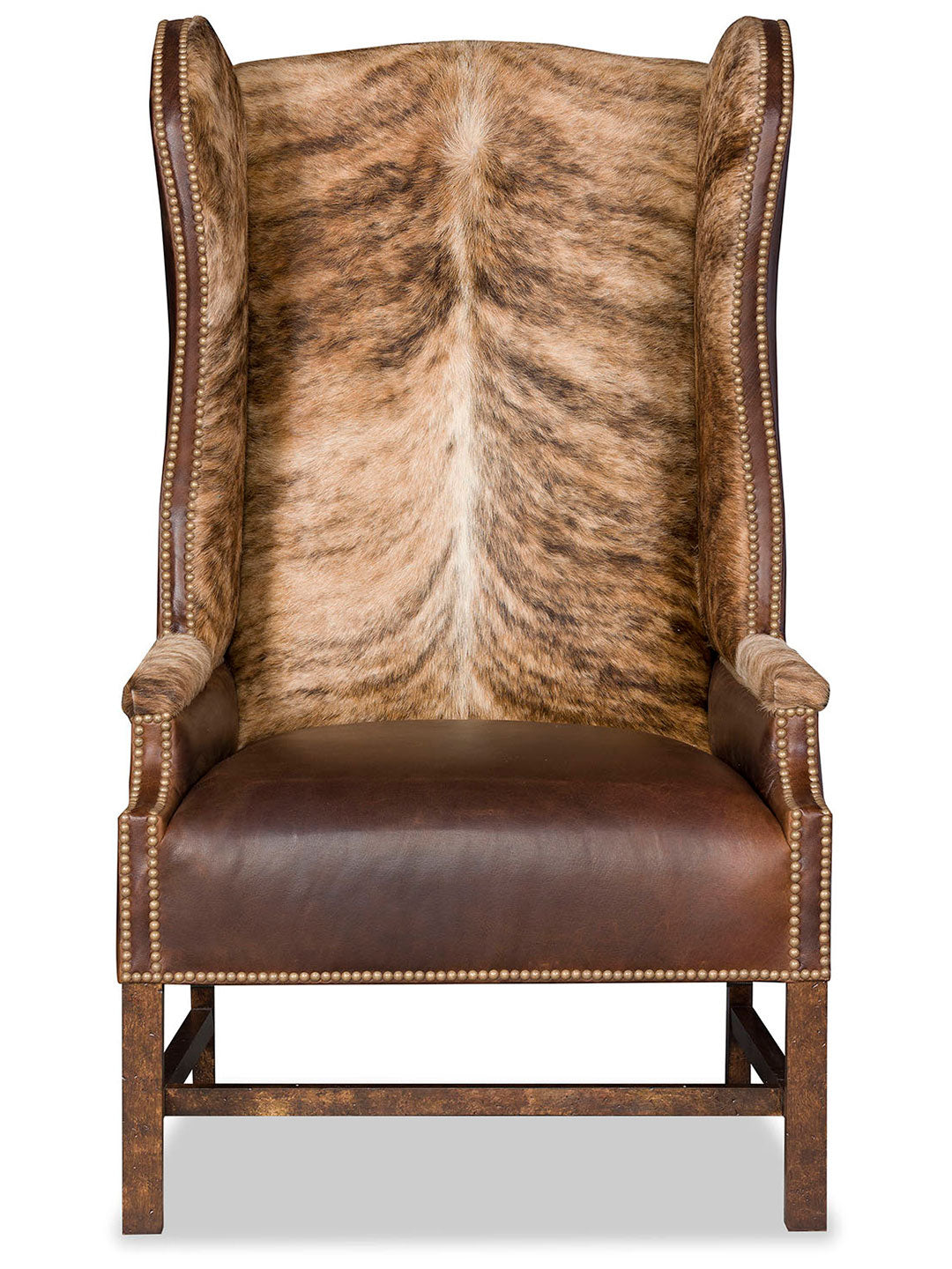 Front view of the Lexi Western Axis Accent Chair, featuring a high wingback design upholstered in genuine axis deer hide with a symmetrical spine pattern, paired with smooth brown leather on the seat and antique brass nailhead trim.