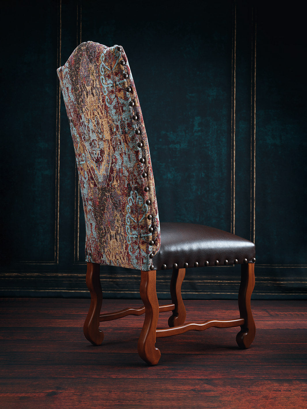A dining chair with a brown leather seat and a floral pattern fabric on the backrest, featuring a wooden frame and legs.