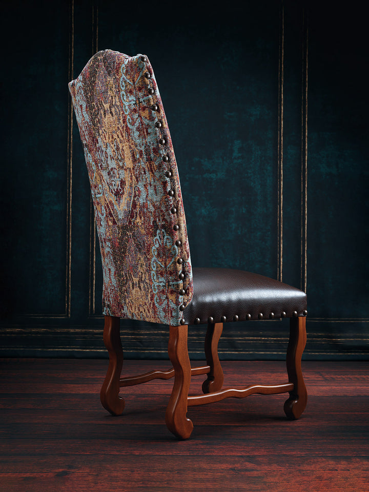 A dining chair with a brown leather seat and a floral pattern fabric on the backrest, featuring a wooden frame and legs.