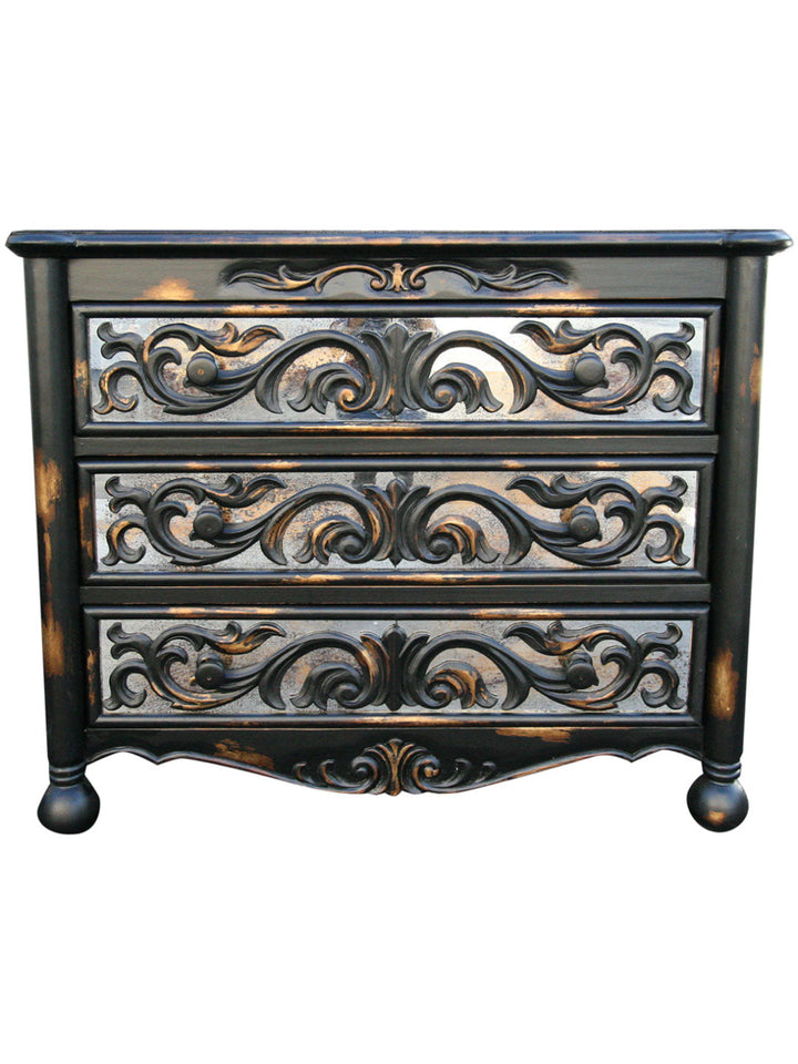 A vintage-style wooden dresser with ornate design and a dark finish, featuring three drawers with intricate details.
