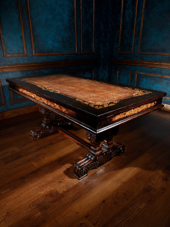 A large, ornate wooden desk with intricate carvings, featuring a rich wood finish and a leather top, set against a room with blue walls.