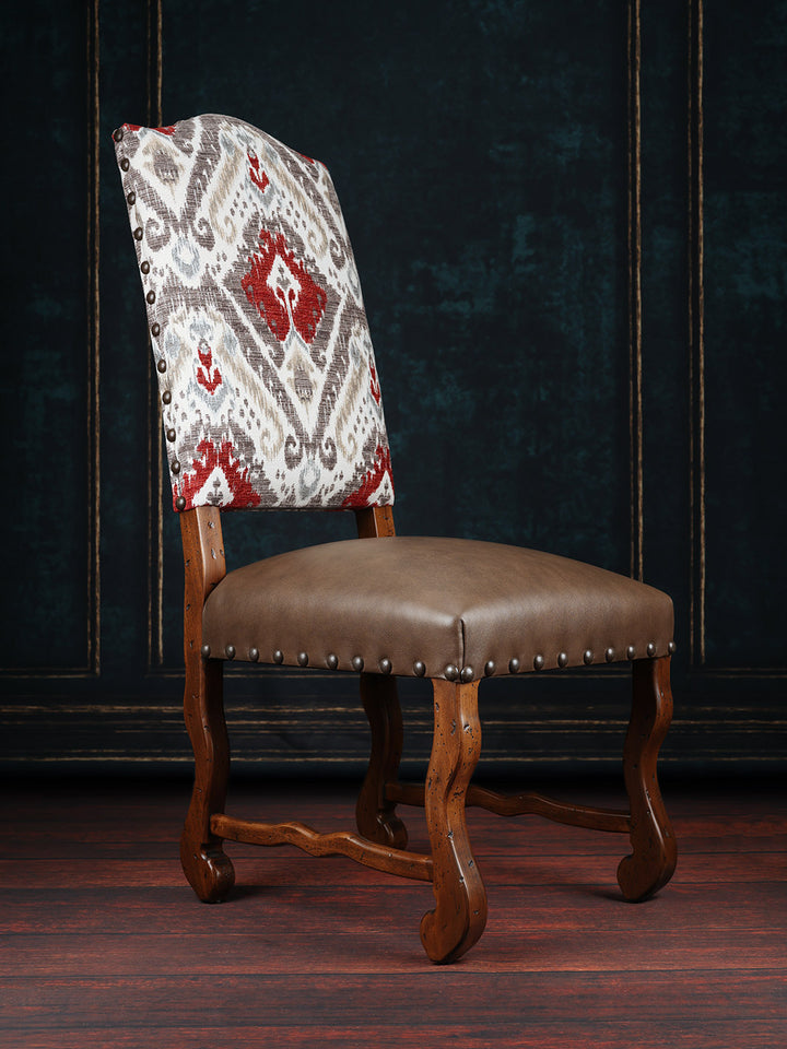 A classic rustic dining chair with a floral backrest fabric, a brown leather seat, and a wooden frame.