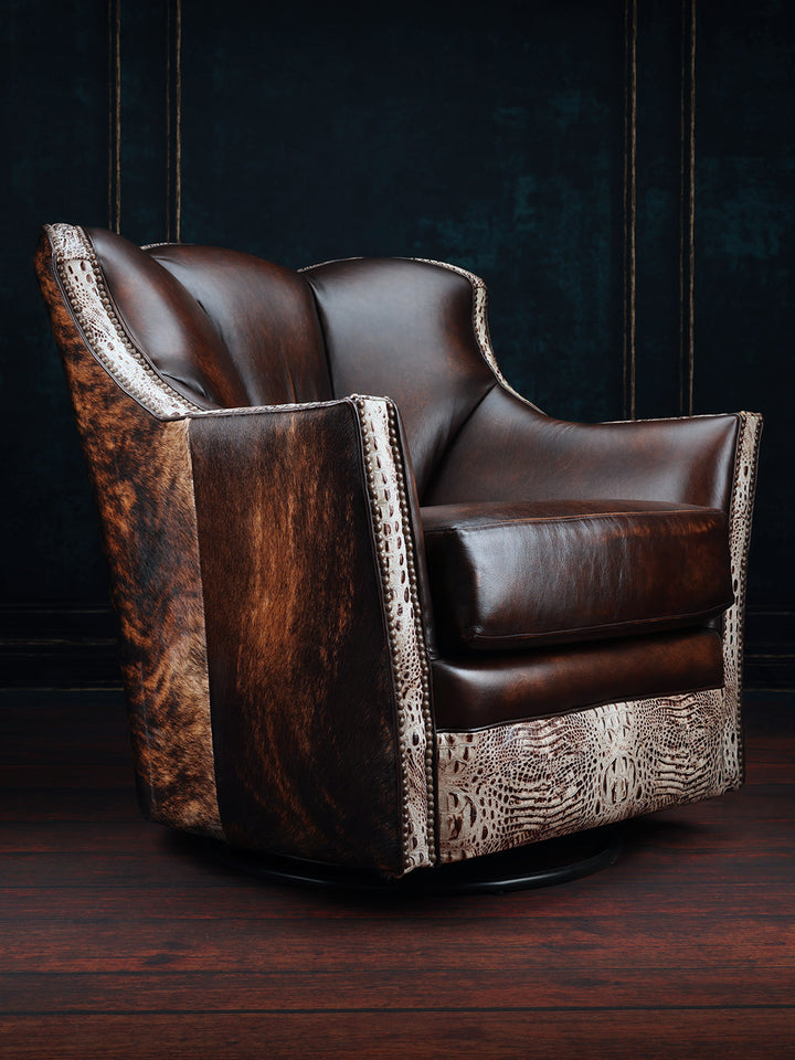 A brown leather swivel chair with cowhide accents on the outside back and arms, placed against a dark background.