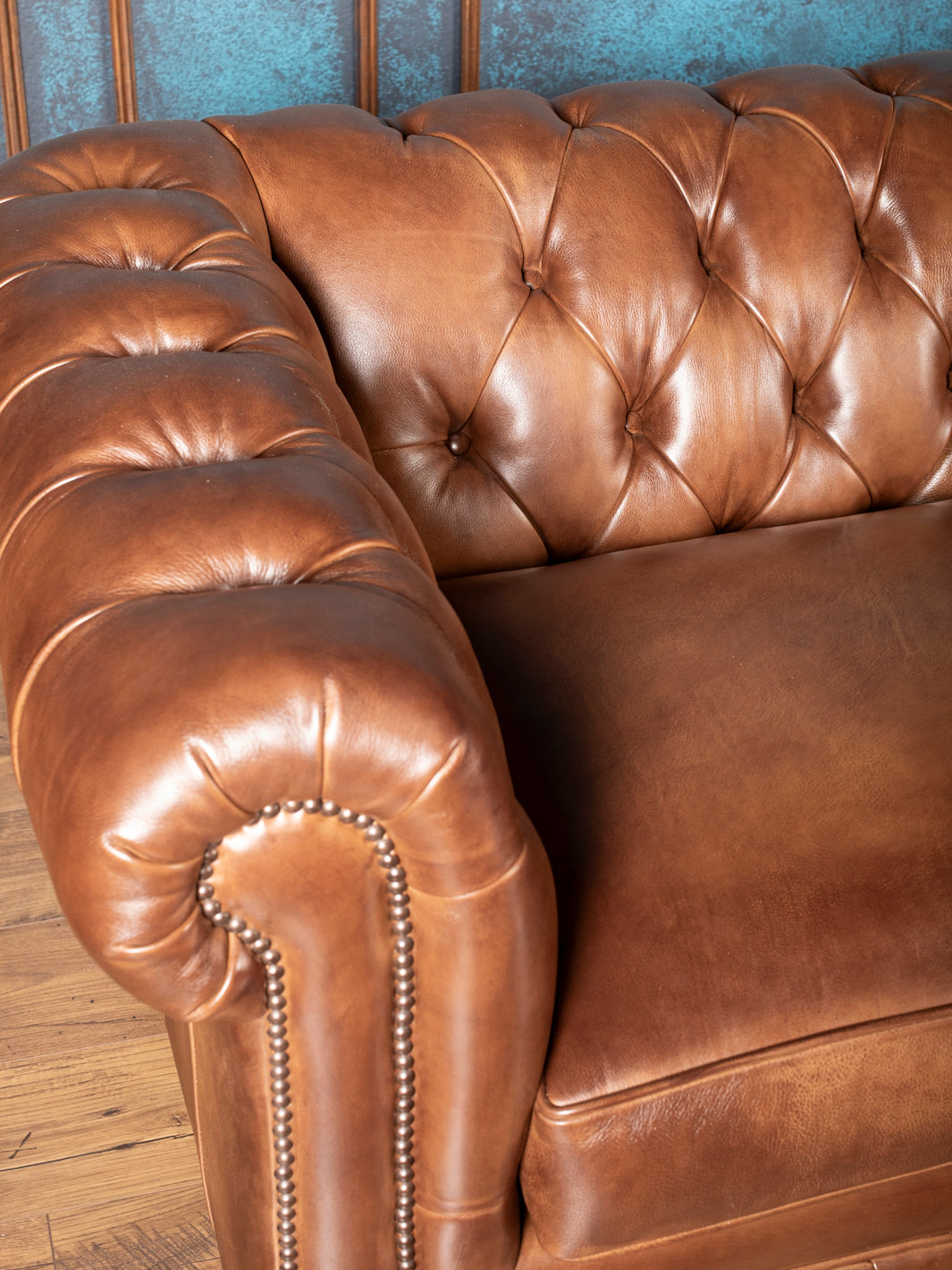 classic almond brown tufted leather Chesterfield couch with high backrest, deep diamond buttoning and padded rolled arm