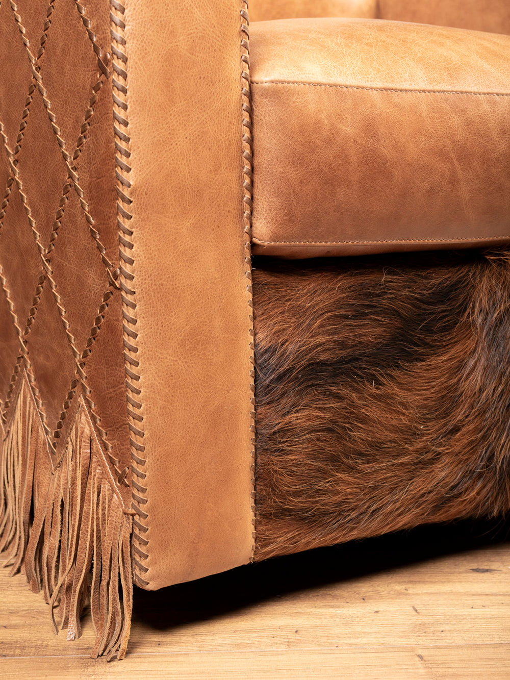 Close-up of hand-laced leather and tri-color cowhide on Belmont Swivel Chair