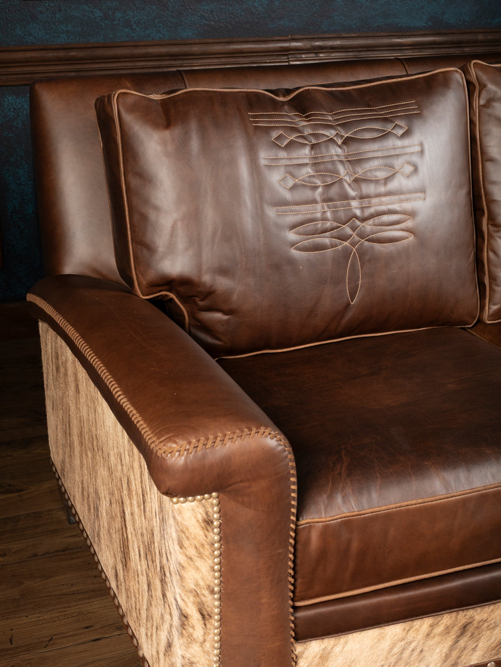 Heritage Whipstitch sofa arm with brown leather, contrasting whipstitch trim, cowhide panel and nailhead accents.
