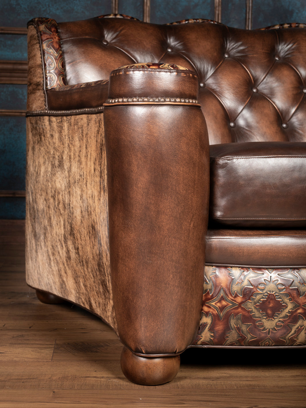 Close-up of back corner and arm: Burnished leather arm meets hair-on-hide back with hand-applied nailhead detail