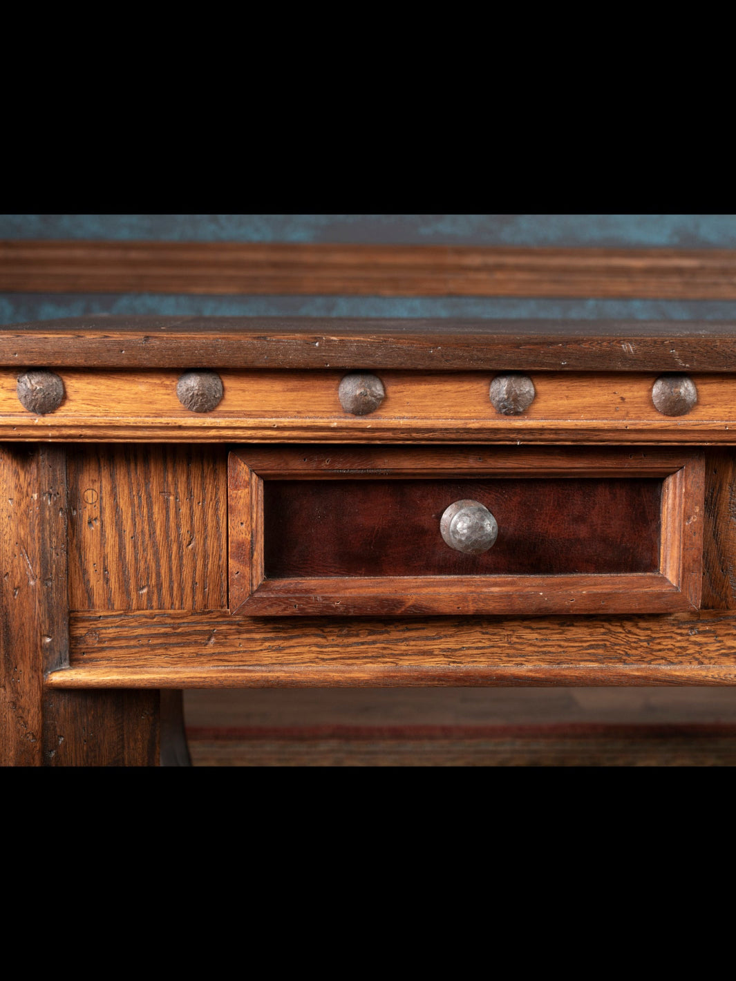Close-up of a wooden desk with metal knobs on a dark background