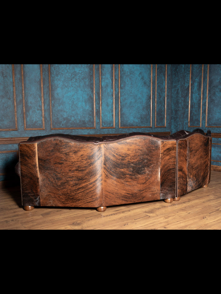 Back angle of the curved sofa featuring dark cowhide back paneling