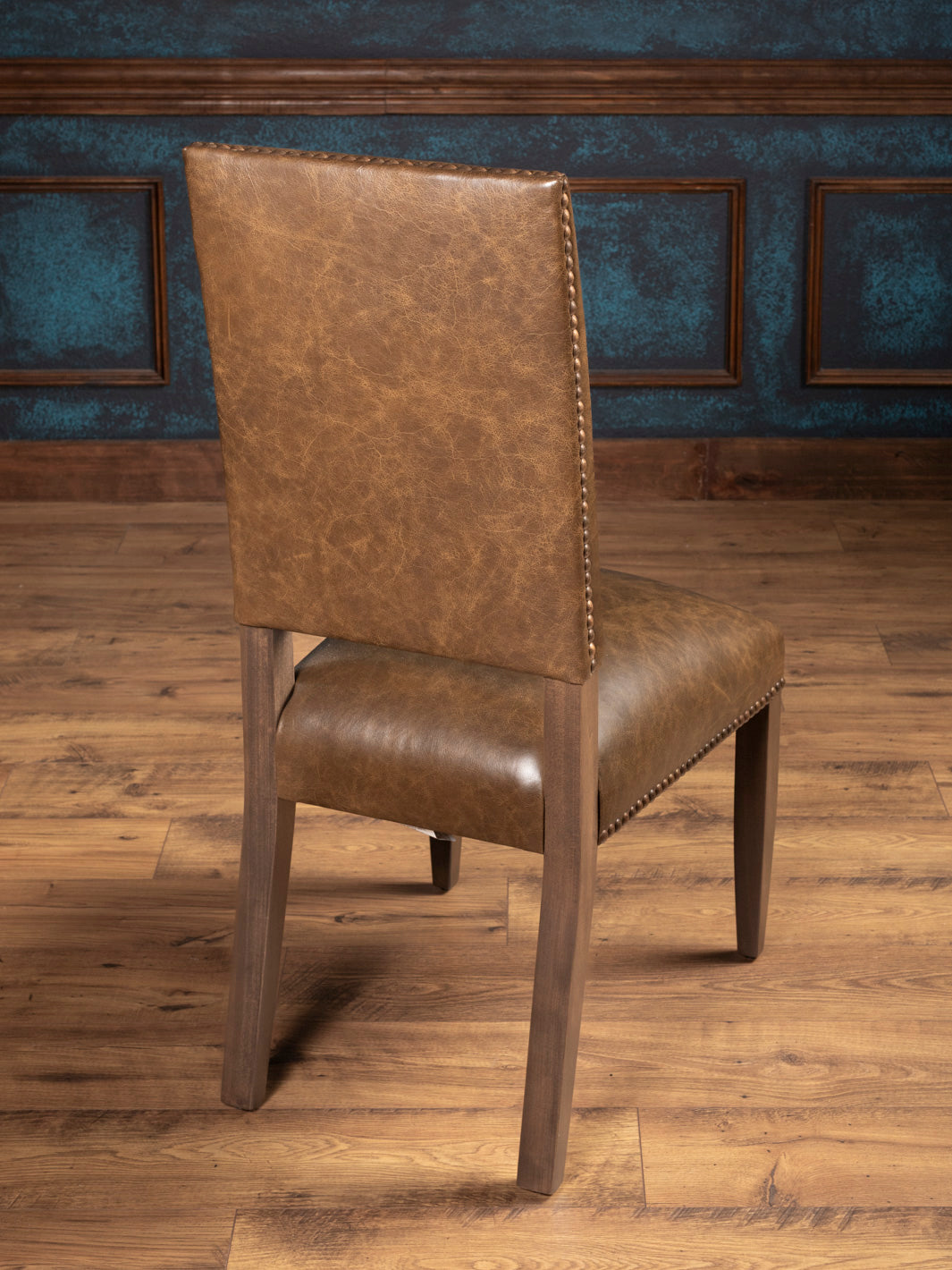 Rear view of the Everlast Side Chair showing leather back and wooden legs