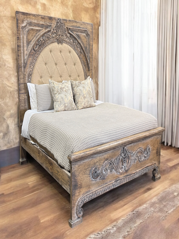 Decorative wooden bed with intricate carvings in a bedroom setting.